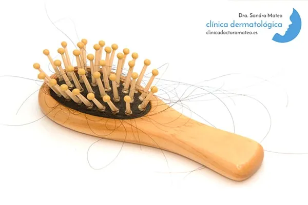 Cepillo de madera con pelos caídos enredados entre las púas