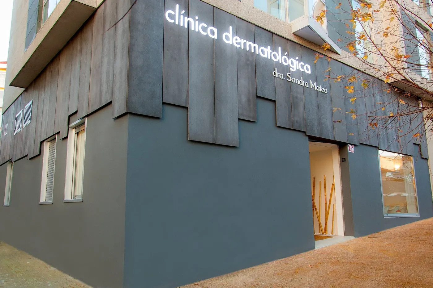 Fachada de vieiro’17 en Santiago de Compostela: la esquina del edificio, revestida de placas grises, con el rótulo iluminado en lo alto y la entrada abierta a pie de calle.